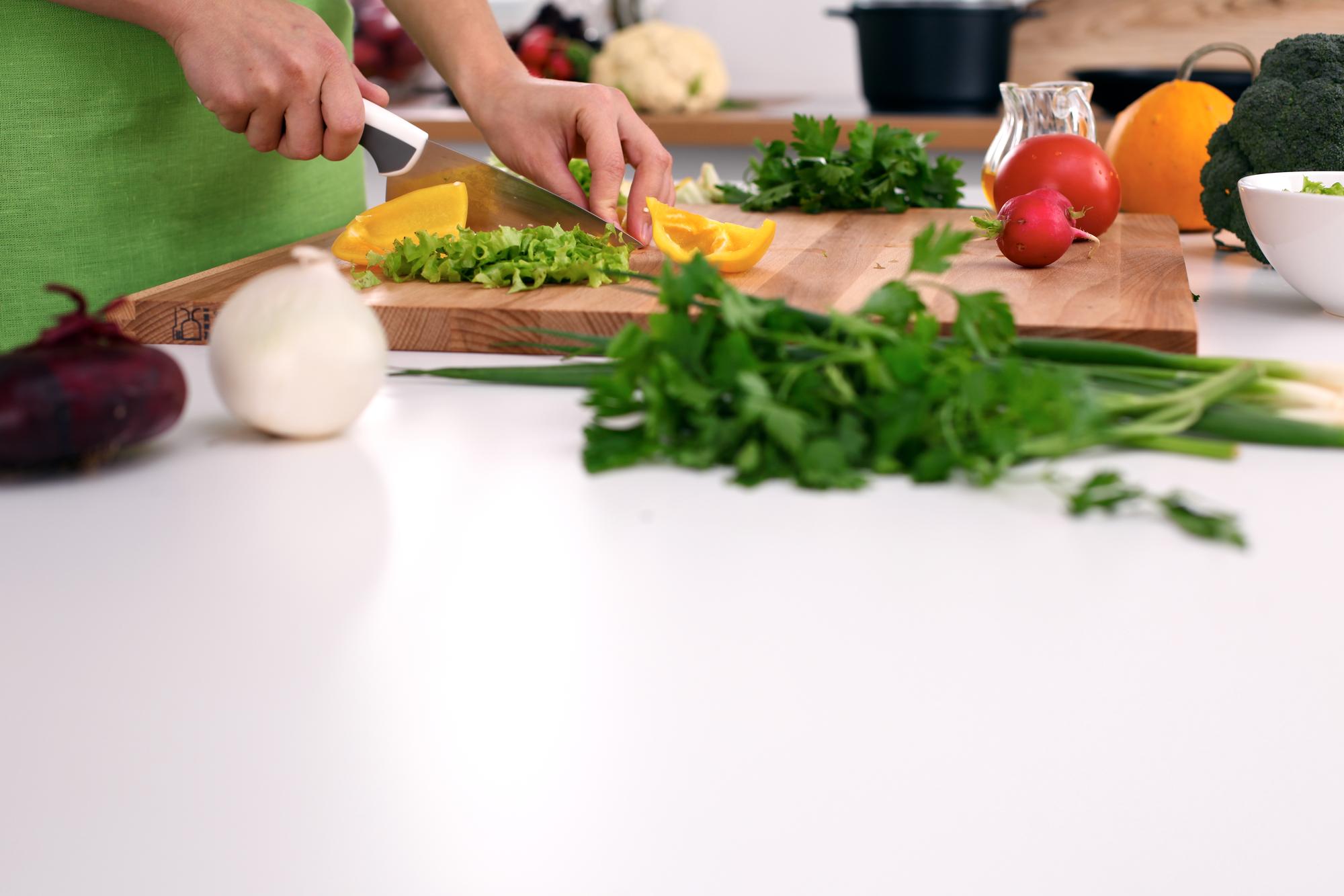 Students chopping vegetables in a bright kitchen